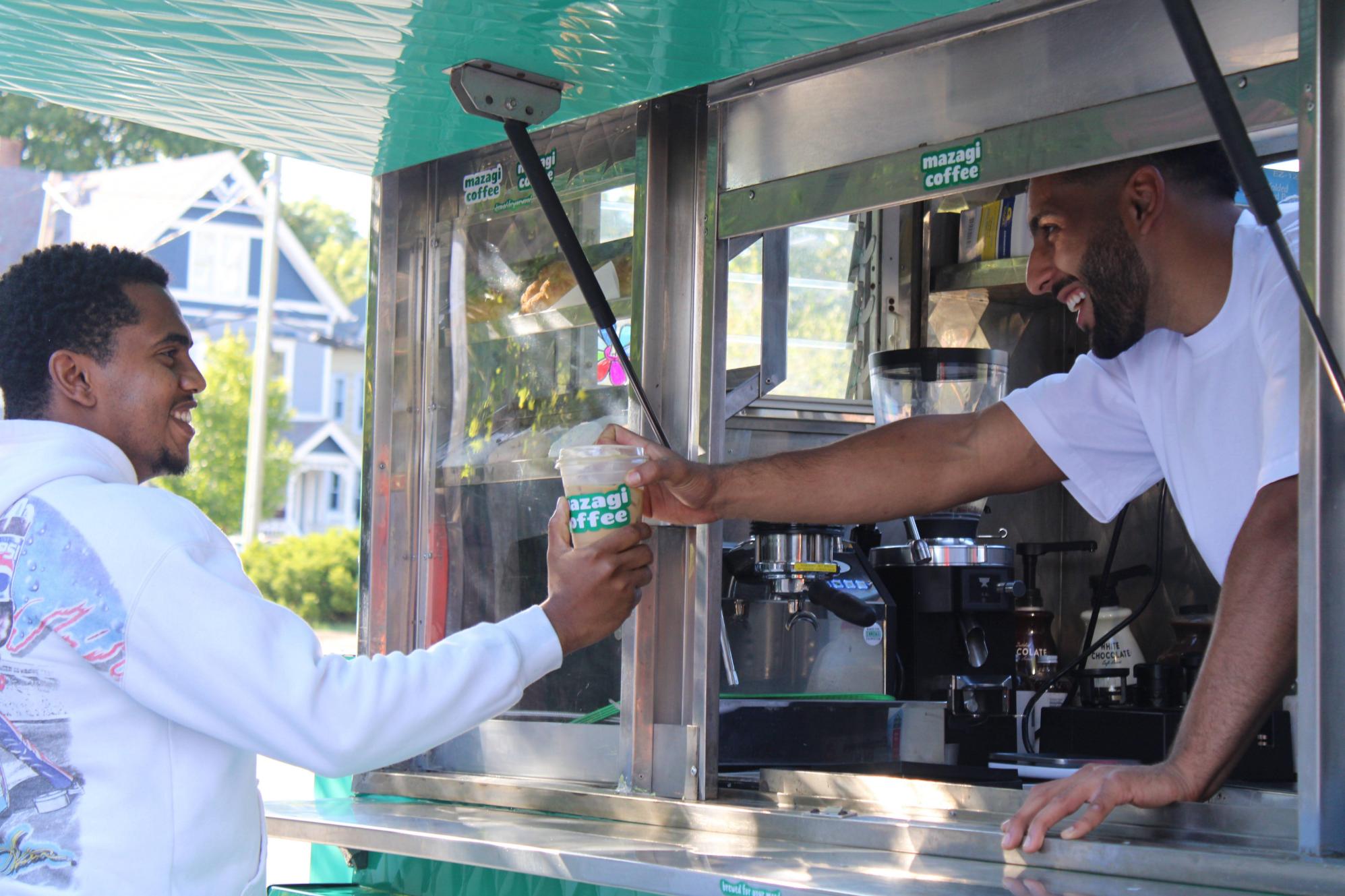 Mazagi barista serving coffee from the mobile coffee cart